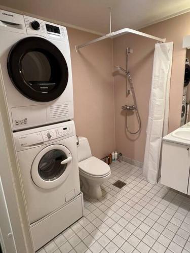 uma casa de banho com uma máquina de lavar roupa e um WC em Modern apartment nearby city centrum em Tromsø