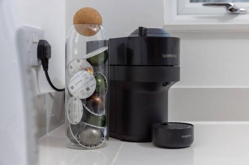 a glass bottle of wine next to a coffee maker at 82 Van Road in Caerphilly