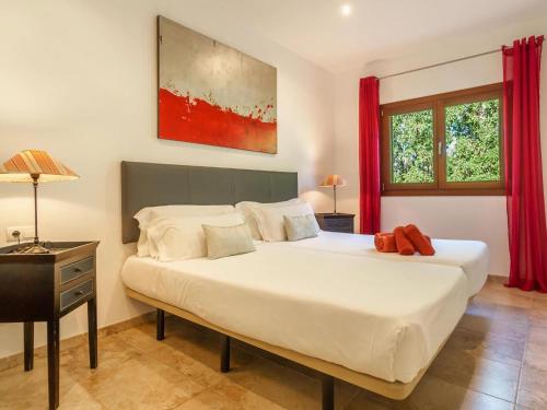 サ・ポブラにあるFour-Bedroom Villa Sa Poblaのベッドルーム(赤いカーテン付きの白い大型ベッド1台付)