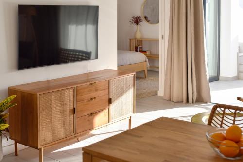 a living room with a tv on a wall at Luxury aparment in casilla de costa with Jacuzzi- Follow the sun in La Oliva