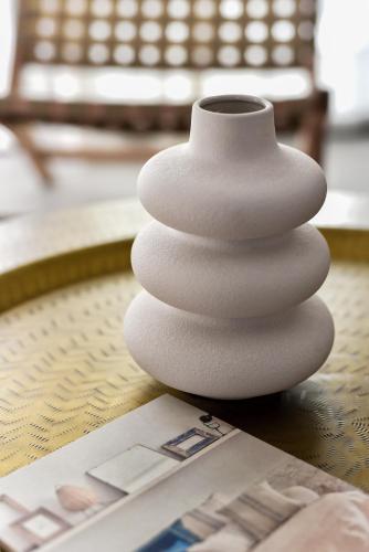 a white vase sitting on a table next to a magazine at Luxury aparment in casilla de costa with Jacuzzi- Follow the sun in La Oliva