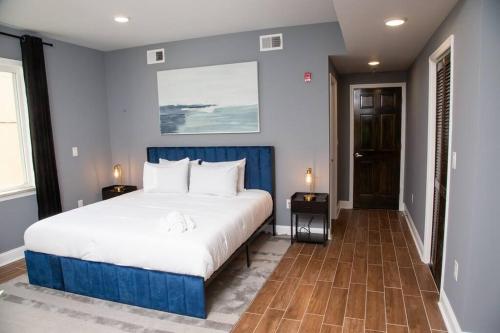 a bedroom with a large white bed and blue walls at Lux Stay by Center City/Temple in Philadelphia