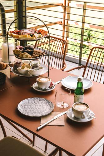a table with plates of food and cups of coffee at OVINA`s HAUS in Sand in Taufers