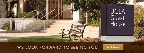 a bench sitting in the grass in front of a building at The Inn at UCLA in Los Angeles