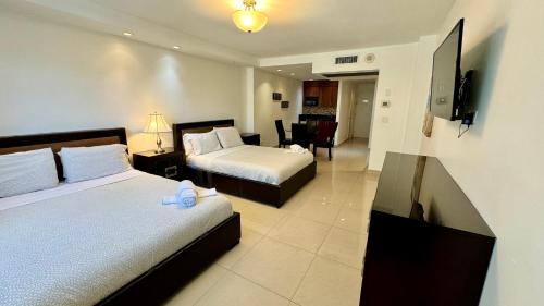 Habitación de hotel con 2 camas y TV en Sunny Isles Condo Resort en Miami Beach
