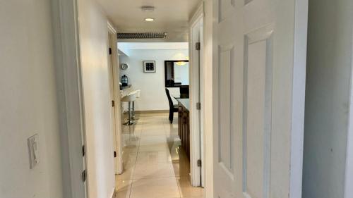 um corredor que leva a uma sala de estar com uma mesa em Sunny Isles Condo Resort em Miami Beach