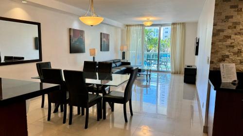 a dining room and living room with a table and chairs at Sunny Isles Condo Resort in Miami Beach