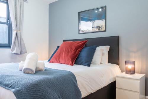 um quarto com uma cama com almofadas vermelhas e azuis em 1 bed pontcanna getaway em Cardiff