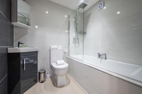 uma casa de banho branca com um WC e um chuveiro em 1 bed pontcanna getaway em Cardiff