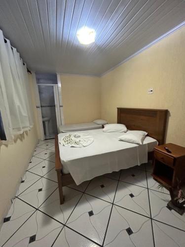 a small bedroom with a bed and a table at Morada do Aventureiro in Angra dos Reis