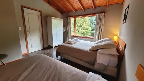 a bedroom with two beds and a window at Bellavista in Villa La Angostura