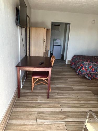 ein kleines Zimmer mit einem Tisch und einem Bett in der Unterkunft Candlelight Inn in St Petersburg