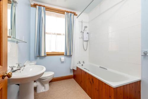 uma casa de banho com uma banheira, um lavatório e um WC. em Bramble Knowe, farm cottage near St Andrews em Dunino