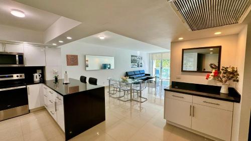 a kitchen with black and white appliances and a dining room at Sunny Isles, beach life! Parking included in Miami Beach