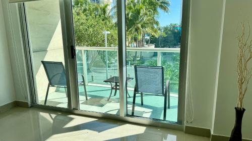 a room with a balcony with two chairs and a table at Sunny Isles, beach life! Parking included in Miami Beach
