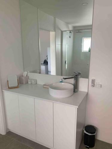 a white bathroom with a sink and a mirror at Tequila Sunset in Yamba