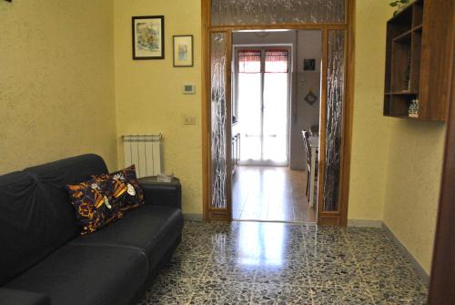 een woonkamer met een zwarte bank en een deur bij Appartamento comodo e accogliente a Ciampino in Ciampino
