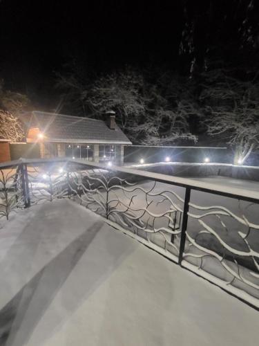a snow covered yard with a fence with lights at БЕРЕЗИНИ in Simer