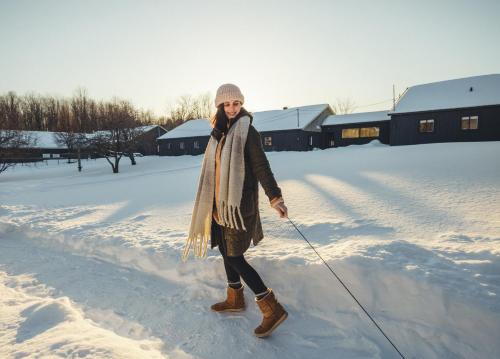 a woman is walking in the snow at Beatnik Hotel in Bromont
