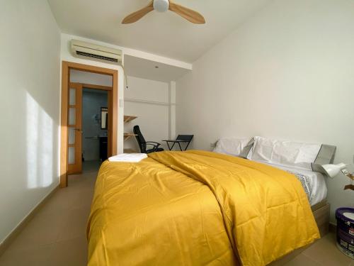 a bedroom with a bed with a yellow blanket at Mini Terraza Relajante Galvani in Terrassa