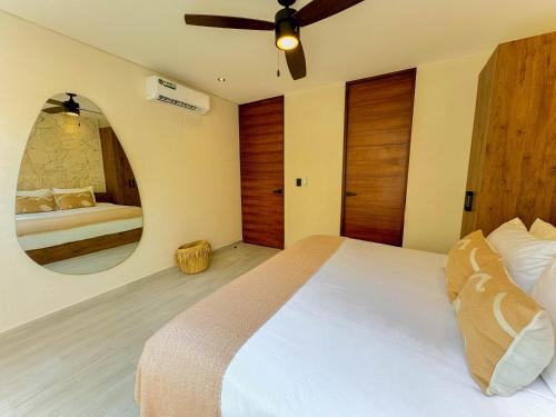Un dormitorio con una cama grande y un espejo. en TÚ REFUGIO EXCLUSIVO EN TULUM, DK JADE 3 By SANDY POWERFUL, en Tulum