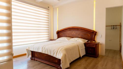 a bedroom with a large bed and a window at Sweet Home Departamento in Loja