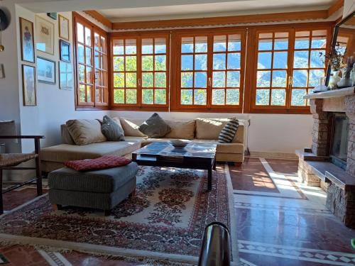 a living room with a couch and a fireplace at Villa Masou Taygetos in Artemisía
