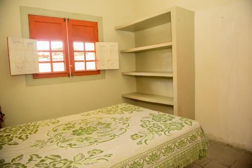 a bedroom with a bed and a window and shelves at Excelente casa c lazer prox a praia Tamandare PE in Tamandaré
