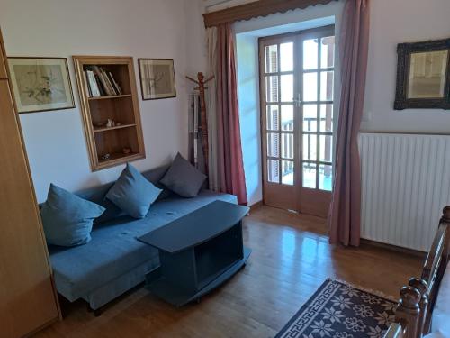 a living room with a blue couch and a table at Villa Masou Taygetos in Artemisía