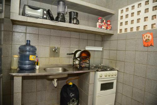 a small kitchen with a sink and a stove at Excelente casa c lazer prox a praia Tamandare PE in Tamandaré