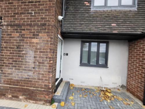 a brick house with a white door and a window at Stay Sleep Rest - Tring Vale in Nottingham