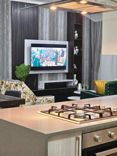 een woonkamer met een fornuis en een tv bij Luxie@92 in Midrand