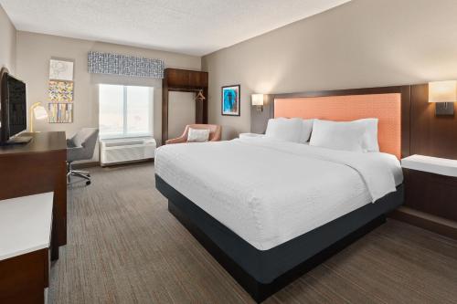 Habitación de hotel con cama grande y escritorio. en Hampton Inn & Suites Scottsburg en Scottsburg