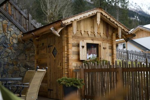 a small wooden house with a fence and a fence at Das Kleinarl in Kleinarl