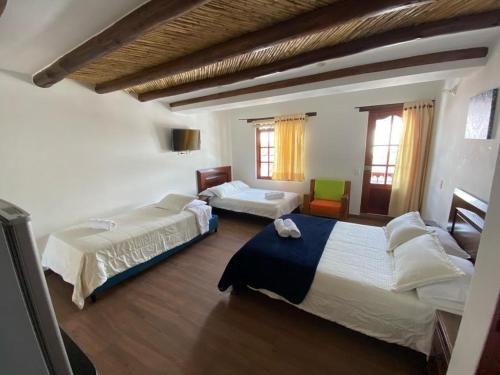 een slaapkamer met 2 bedden in een kamer bij Muisca Hotel Villa de Leyva in Villa de Leyva