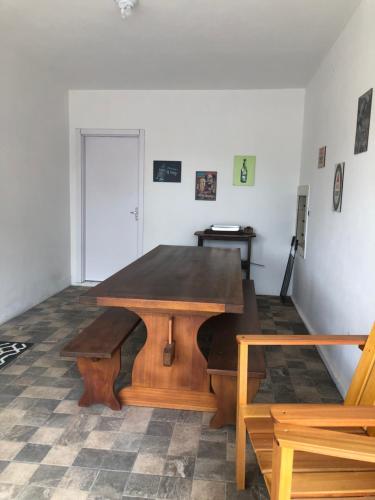 a wooden table in a room with a bench at Casa vermelha, sitio pousada vô maneca in Timbó