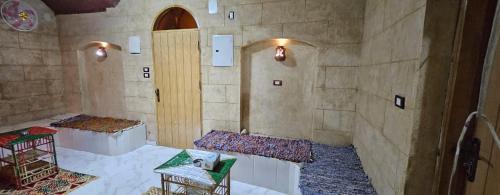 um quarto com duas camas numa parede de pedra em Queen House em Aswan
