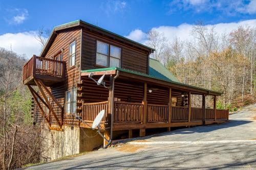 a log cabin with a deck and a balcony at Heavenly Bear, Hot Tub, FREE Attraction tickets for each paid day, Pool Table, WIFI!!! in Sevierville
