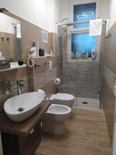 e bagno con servizi igienici, lavandino e doccia. di San Siro Dream Home -Apartment with garage-Milano a Milano