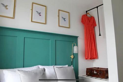a bedroom with a bed and a red dress hanging on a wall at Clement House, York, Free EV and parking in York