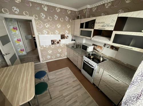 una vista aérea de una cocina con mesa y sillas en House near airport ЖК ЮГ en Prigorodnyy