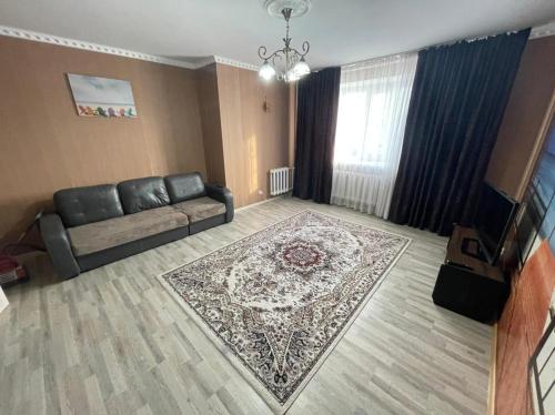 salon z kanapą i dywanem w obiekcie House near airport ЖК ЮГ w mieście Prigorodnyy