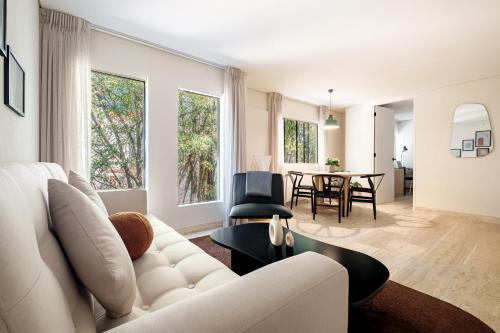 a living room with a white couch and a table at Nido Condesa in Mexico City