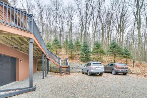 two cars parked in a parking lot next to a house at The Eagles Nest at Alpine Cabin with Fireplace! in Terra Alta