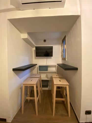 een kamer met twee tafels en een tv aan de muur bij LULU' LESUITES in Cava deʼ Tirreni