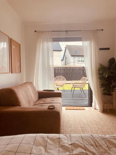 uma sala de estar com um sofá e uma porta de vidro deslizante em The Maiden Studio. Derry city. Studio Apartment. em Derry Londonderry
