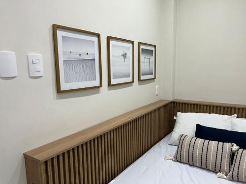 1 dormitorio con 3 cuadros en la pared y 1 cama en Flat Copacabana quadra da praia 907, en Río de Janeiro