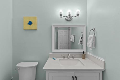 a white bathroom with a sink and a toilet at Loggerhead Inn and Suites in Surf City