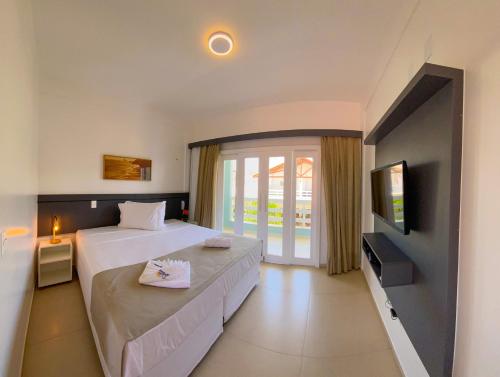 a hotel room with two beds and a television at Pousada Diane in Trairi
