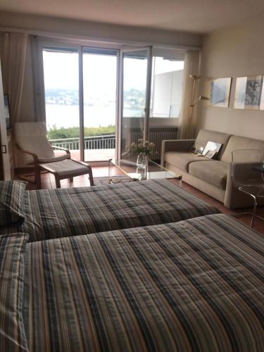 a bedroom with a large bed and a living room at Bellevue- Bellavista in Castagnola